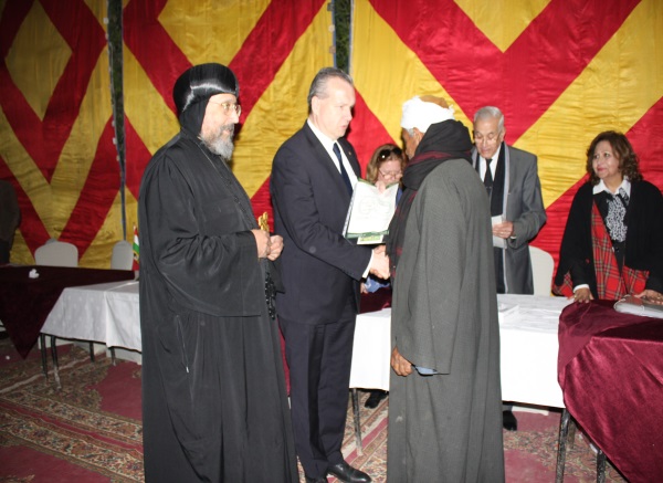 The ownership certificate of the cattle is handed to one of the beneficiaries in the presence of Ermeja bishop